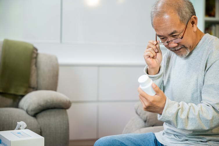 Man looks at medicine bottle